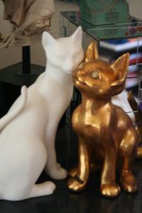 A staue of a white and a golden cat